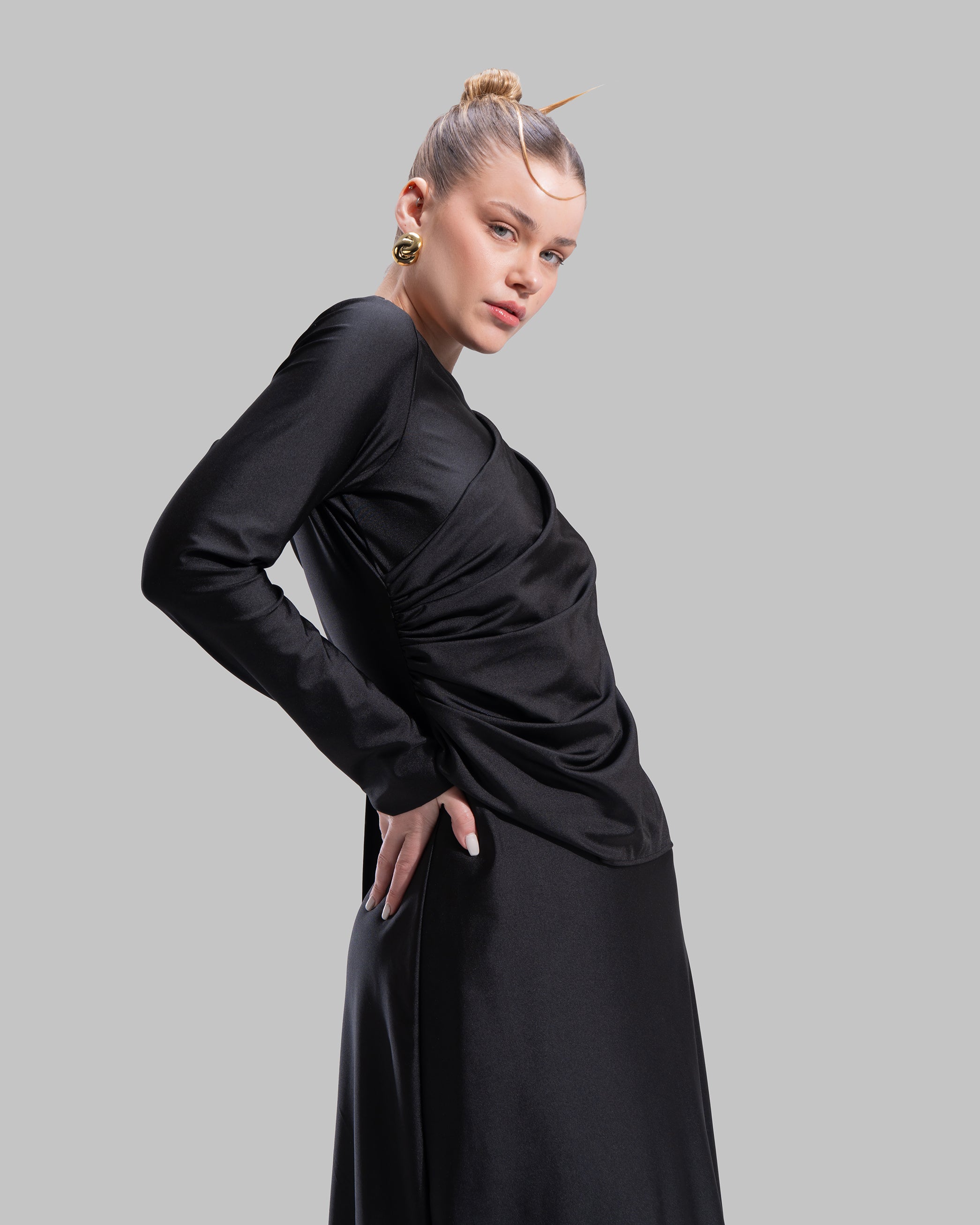 Long draped dress with a round neckline and asymmetrical overlay detail.