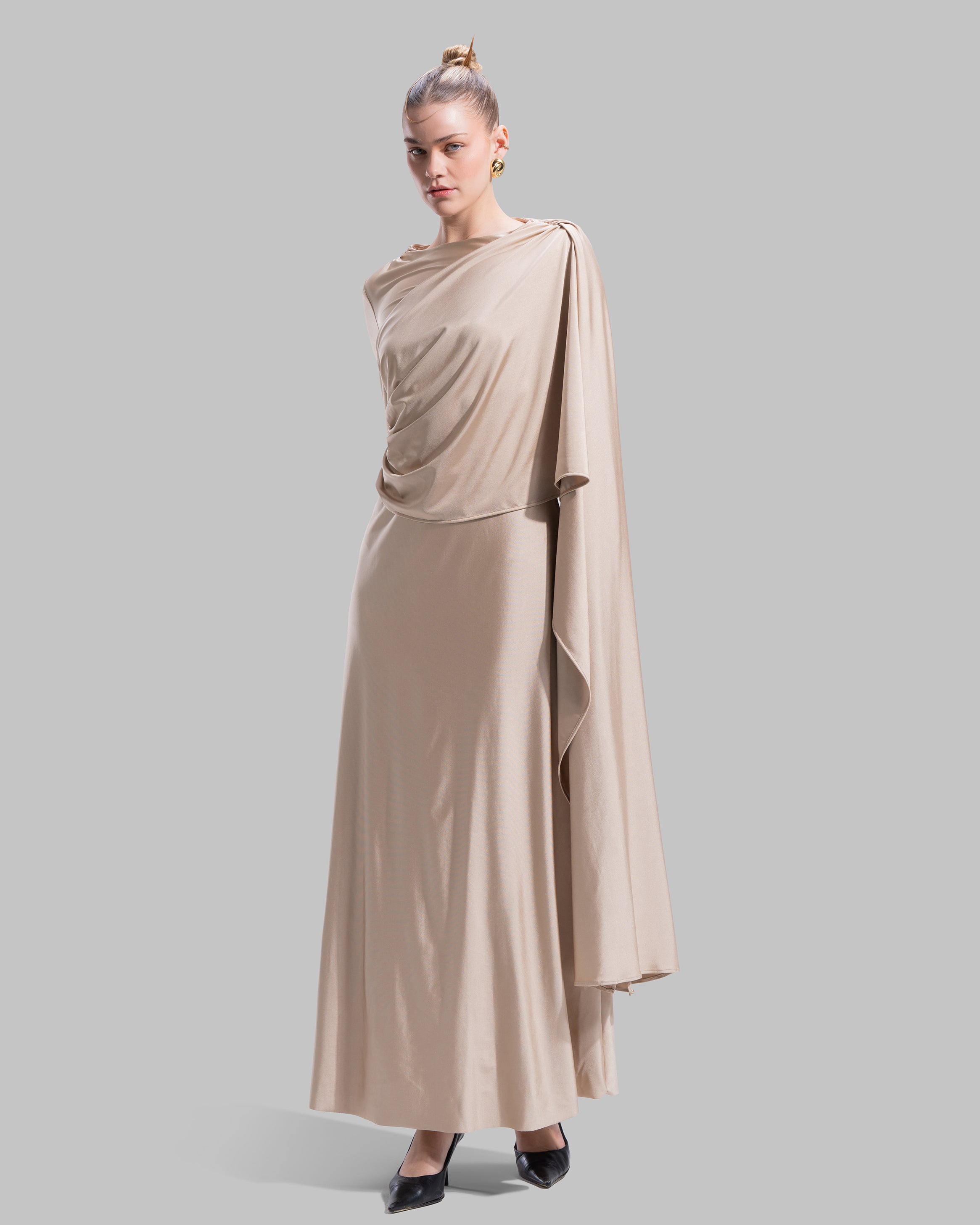 Long draped dress with a round neckline and asymmetrical overlay detail.