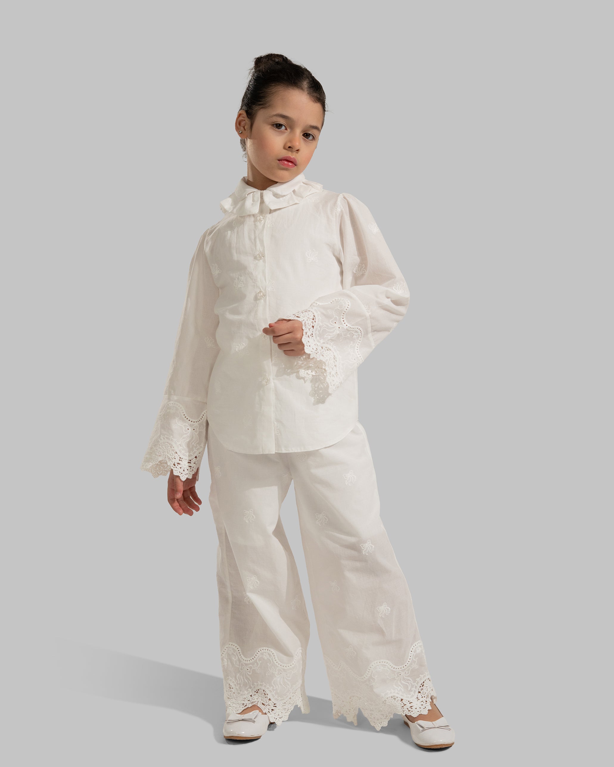 Button-up blouse with a ruffled collar and embroidered lace cuffs.