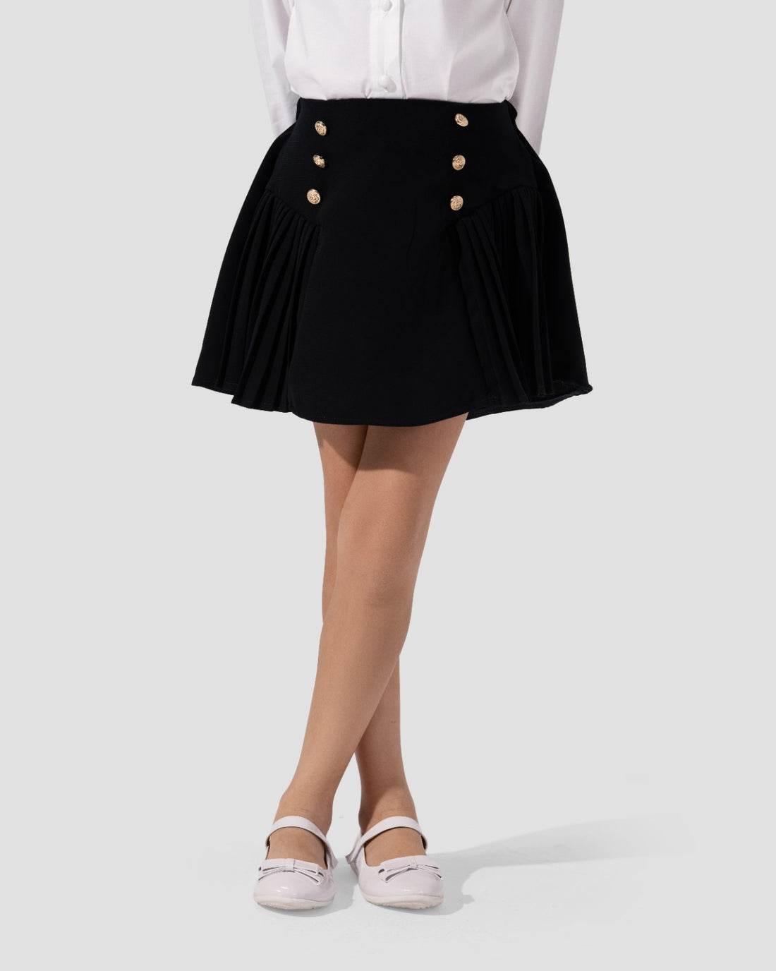 Short pleated skirt in navy blue with gold-tone button detail at the waist