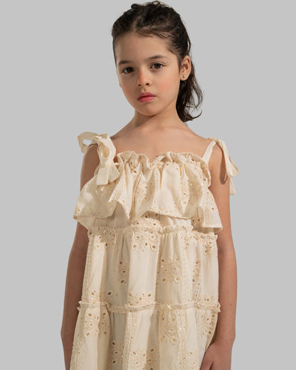 Tiered dress with perforated embroidery, ruffle trim, and tie-up shoulder straps.